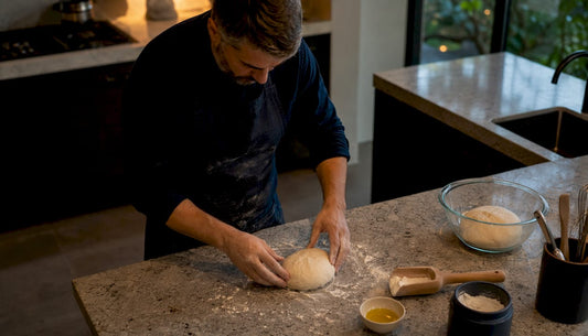 Man stretching Neapolitan pizza dough in kitchen