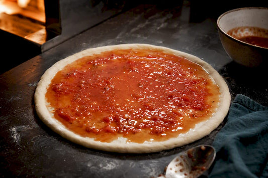 Loose tomato sauce pooling on pizza dough