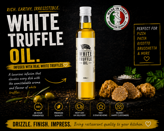 A bottle of White Truffle Oil centered on a dark promotional background, with olives, truffle slices, and Italian quality badges around it. Large text reads 'WHITE TRUFFLE OIL' and includes marketing copy and usage suggestions for pizza, pasta, risotto, and bruschetta.